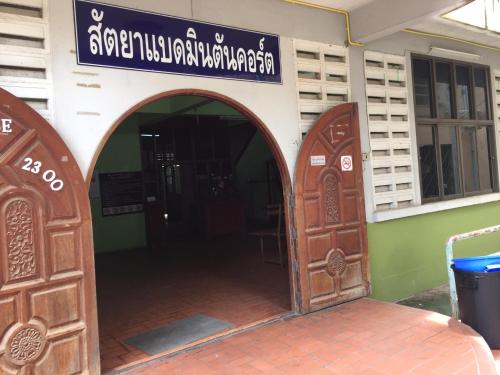 an entrance to a building with two wooden doors at Sataya Apartment in Maha Sarakham