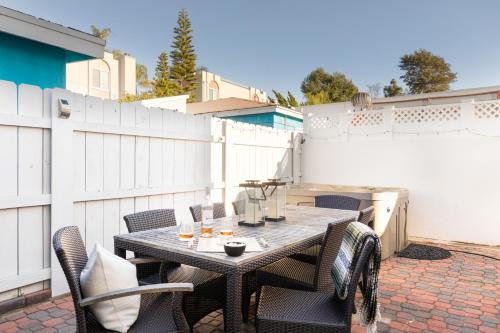 a patio with a wooden table and chairs at Indigo By AvantStay Sleek Charming Home 2 Blks from Bay w Hot Tub in San Diego