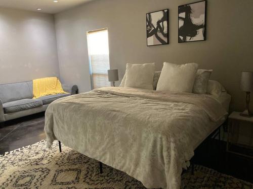 a bedroom with a large bed and a couch at 10 min airport 15 min PD Canyon in Amarillo
