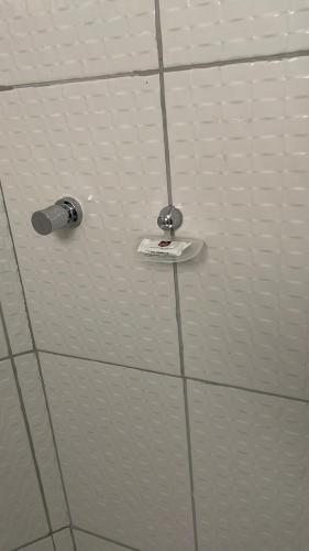 a white tiled wall with a toothbrush at Mauri Center Hotel in Picos