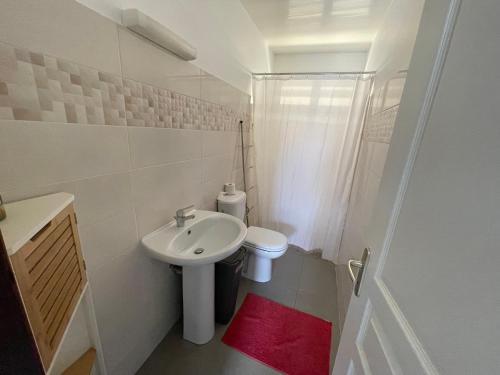 ein weißes Bad mit einem Waschbecken und einem WC in der Unterkunft Maison de Bourda in Cayenne