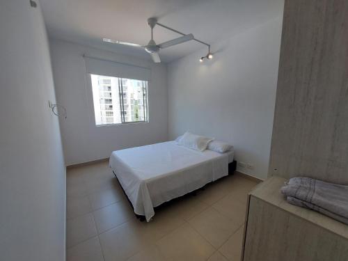 een witte slaapkamer met een bed en een raam bij Apartamento Aqualina Orange Piso 5 Vista a Montañas 2 Habitaciones in Girardot