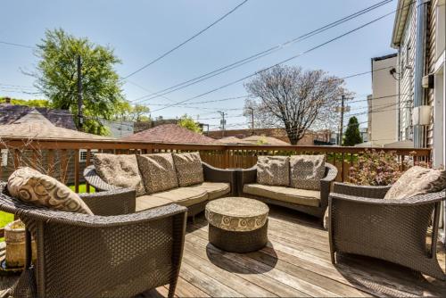 a patio with wicker furniture on a wooden deck at Garage Parking - Vintage Charm - and a Fabulous Location! Easily Enjoy the Best of Chicago! in Chicago