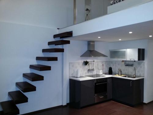 a kitchen with a black staircase in a white wall at Kodaly Art Apartment in Budapest
