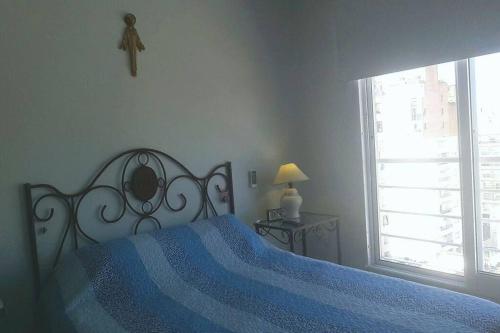 1 dormitorio con 1 cama con manta azul y ventana en Rosario siempre estuvo cerca en Rosario