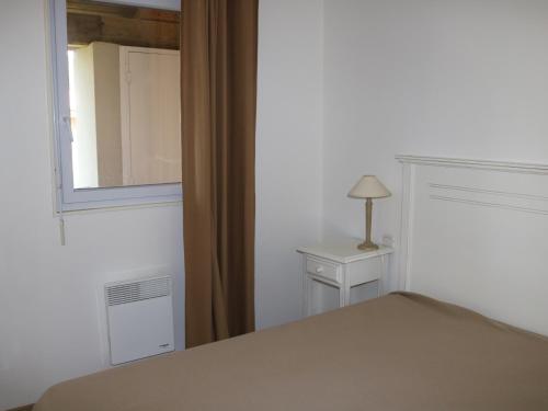 - une chambre avec un lit, une fenêtre et une lampe dans l'établissement Charmant apt à Parentis avec piscine, 4 pers, près du lac, ménage inclus - FR-1-319-444, à Parentis-en-Born