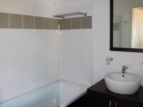 une salle de bain blanche avec un lavabo et un miroir dans l'établissement Charmant apt à Parentis avec piscine, 4 pers, près du lac, ménage inclus - FR-1-319-444, à Parentis-en-Born