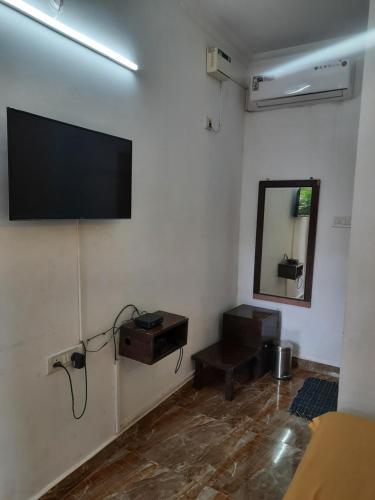 a room with a flat screen tv on the wall at Cherry blossom guest house in Arpora