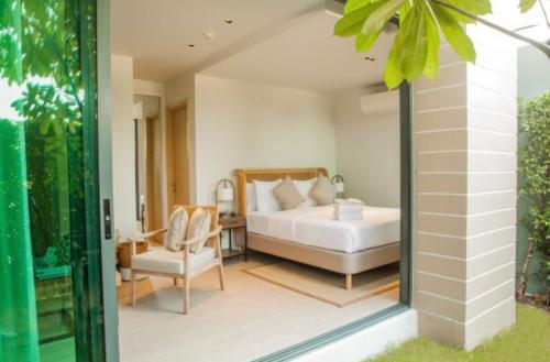 1 dormitorio en una villa con 1 cama y 1 silla en Fisherman House Residence Pranburi, en Sam Roi Yot