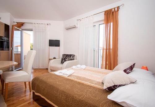 1 dormitorio con 1 cama grande, mesa y sillas en Apartments PREMANTURA DOM, en Premantura