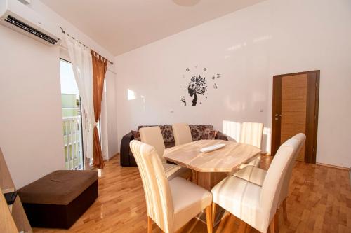 a dining room with a wooden table and chairs at Apartments PREMANTURA DOM in Premantura