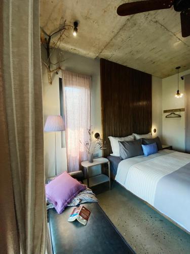 a bedroom with two beds and a table with a book at Kaia Gallery Hotel Hoi An in Hoi An