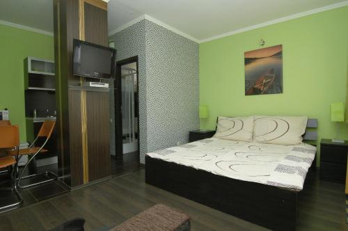1 dormitorio con 1 cama y TV en Apartment Color Beach, en Siófok