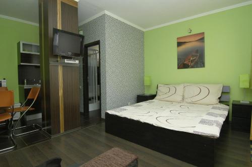 a bedroom with a bed and a television in it at Apartment Color Beach in Siófok