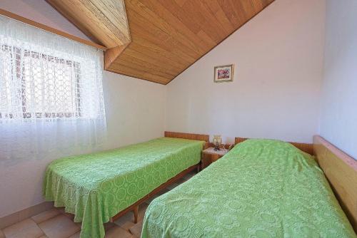 2 camas en una habitación con ventana en Apartments Lucija en Postira