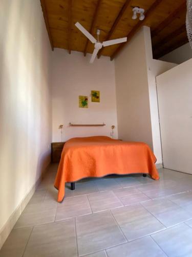 una habitación con una cama con una sábana naranja. en Complejo Anita 07 en Las Grutas