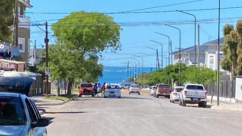 una calle con coches estacionados al costado de la carretera en Complejo Anita 07 en Las Grutas