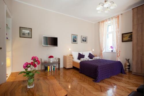 sypialnia z łóżkiem i wazonem kwiatów na drewnianej podłodze w obiekcie Apartment Mario w Splicie