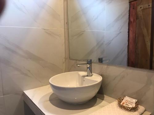 a bathroom with a white bowl sink and a mirror at Hostería los Cedros de Mindo in Mindo
