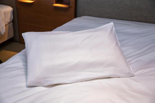 a white pillow sitting on top of a bed at Hotel JAL City Haneda Tokyo in Tokyo