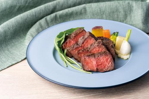 a plate of steak and vegetables on a table at Hotel JAL City Haneda Tokyo in Tokyo