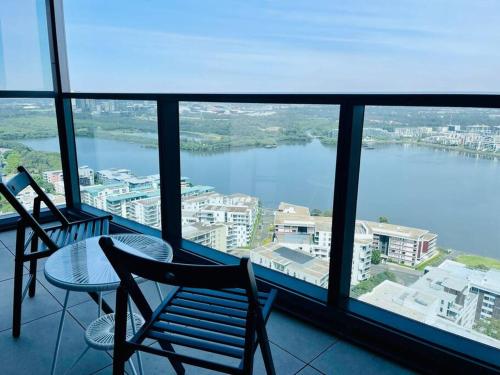 a balcony with a table and chairs and a view of a river at New Luxury stunning water view 2bed2bath Condo in Sydney