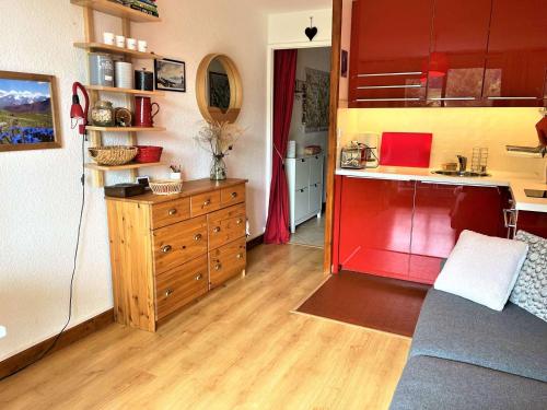 Il comprend une cuisine avec des placards rouges et du parquet. dans l'établissement Studio Montagne 4 Pers. près Pistes et Commerces - La Salle les Alpes - FR-1-330F-204, à La Salle Les Alpes