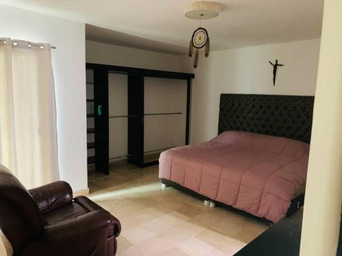 a bedroom with a bed and a couch and a chair at Casa Boca in Boca del Río