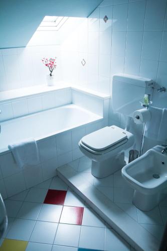 a white bathroom with a toilet and a sink at Casa Agnese in Alba