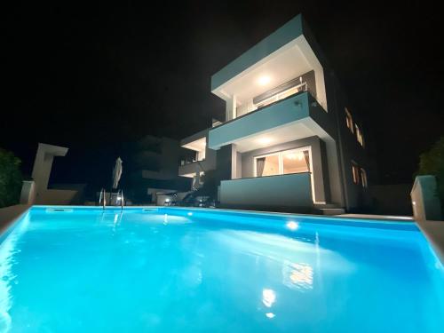 una piscina di fronte a una casa di notte di Fantasy Pool Villa - Deluxe Apartment a Novalja (Novaglia)