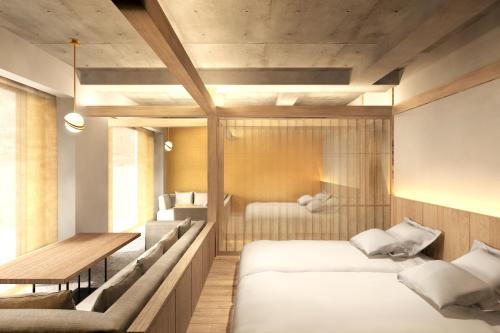 a bedroom with two beds and a table and chairs at Kyoto ITOYA Hotel Mon in Kyoto