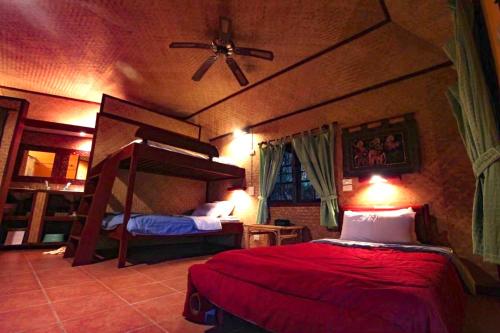 een slaapkamer met 2 stapelbedden en een plafondventilator bij Old Tree's House ThaTon in Mae Ai