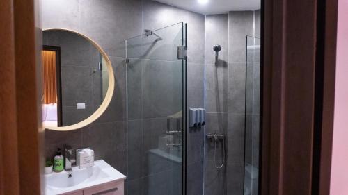 ein Bad mit einer Dusche, einem Waschbecken und einem Spiegel in der Unterkunft HOTEL ALKQUIMIA in Bayahibe