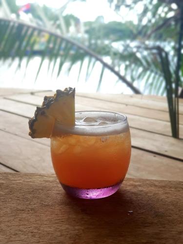 a drink sitting on top of a wooden table at The Hideaway in Kampot