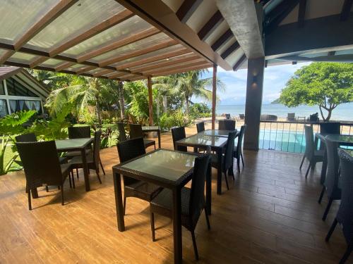 a restaurant with tables and chairs and a view of the ocean at Amila Dive Beach Resort in Sipalay