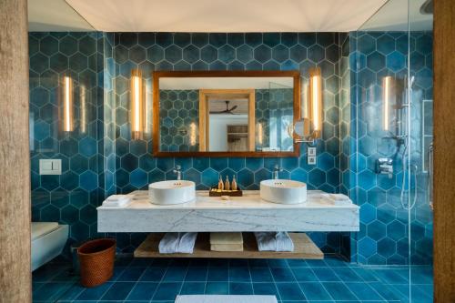 a bathroom with two sinks and a mirror at Ahu Bay in Ahungalla