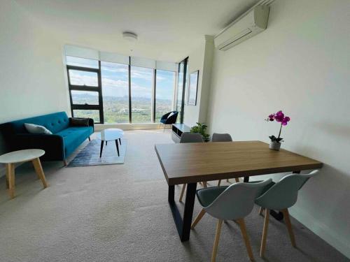 a living room with a table and a blue couch at Panoramic City View 3bed2bath condo Wi-Fi Parking in Sydney