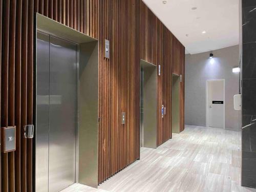 an empty hallway with wooden walls and glass doors at Panoramic City View 3bed2bath condo Wi-Fi Parking in Sydney