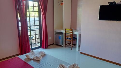 a room with a bed and a table and a desk at Answer hotel in Puerto Galera