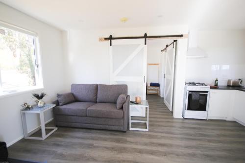 a living room with a couch and a kitchen at Glen Lough Cabins in Glen Aplin