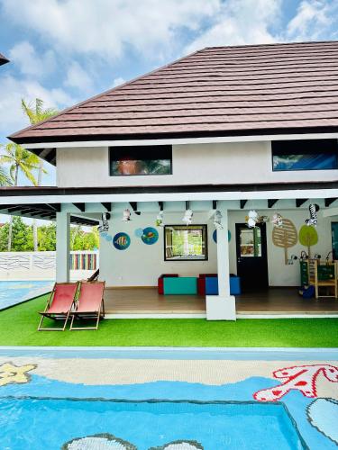 a house with a pool in front of it at OBLU XPERIENCE Ailafushi - All Inclusive with Free Transfers in Male City