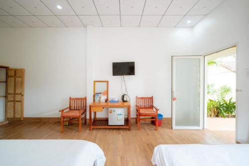 a bedroom with a table and two chairs and a tv at Thai Tan Tien Hotel in Phu Quoc