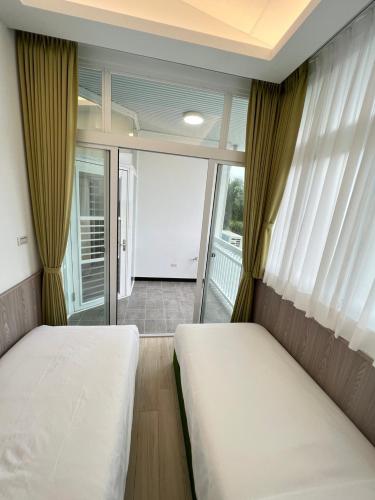 a bedroom with two beds and a large window at 高一 33 班 Homestay 1982 in Chenggong