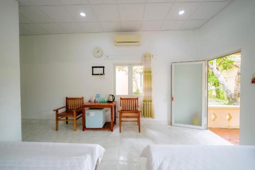 a bedroom with a table and chairs and a room with a window at Thai Tan Tien Hotel in Phu Quoc