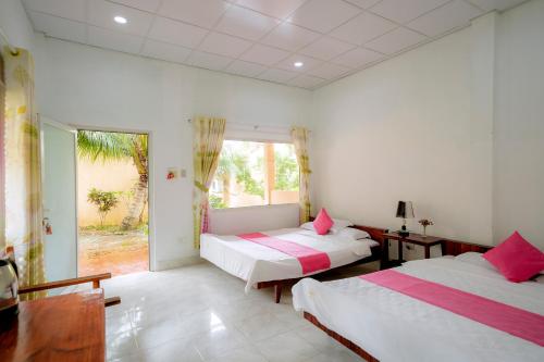 a bedroom with two beds and a large window at Thai Tan Tien Hotel in Phu Quoc