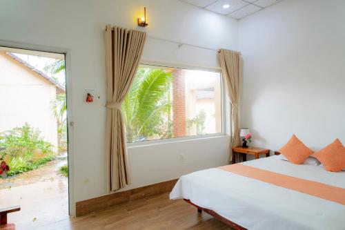 a bedroom with a bed and a large window at Thai Tan Tien Hotel in Phu Quoc
