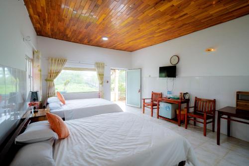 a bedroom with two beds and a wooden ceiling at Thai Tan Tien Hotel in Phu Quoc