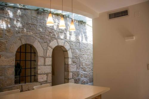 Habitación con mesa y pared de piedra. en Cozy Heritage Home Jerusalem, en Jerusalén