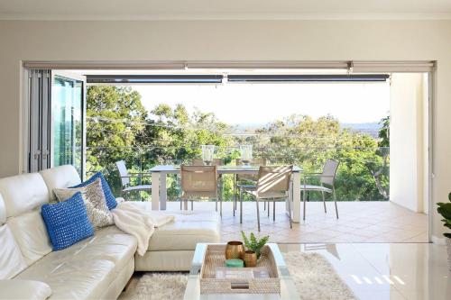 a living room with a couch and a table at 15 Nairana Rest Noosa Heads in Noosa Heads