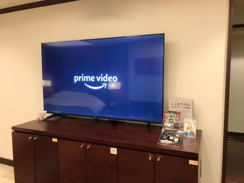 a flat screen tv on top of a wooden cabinet at Hotel Water Gate Tokuyama adult only in Shunan